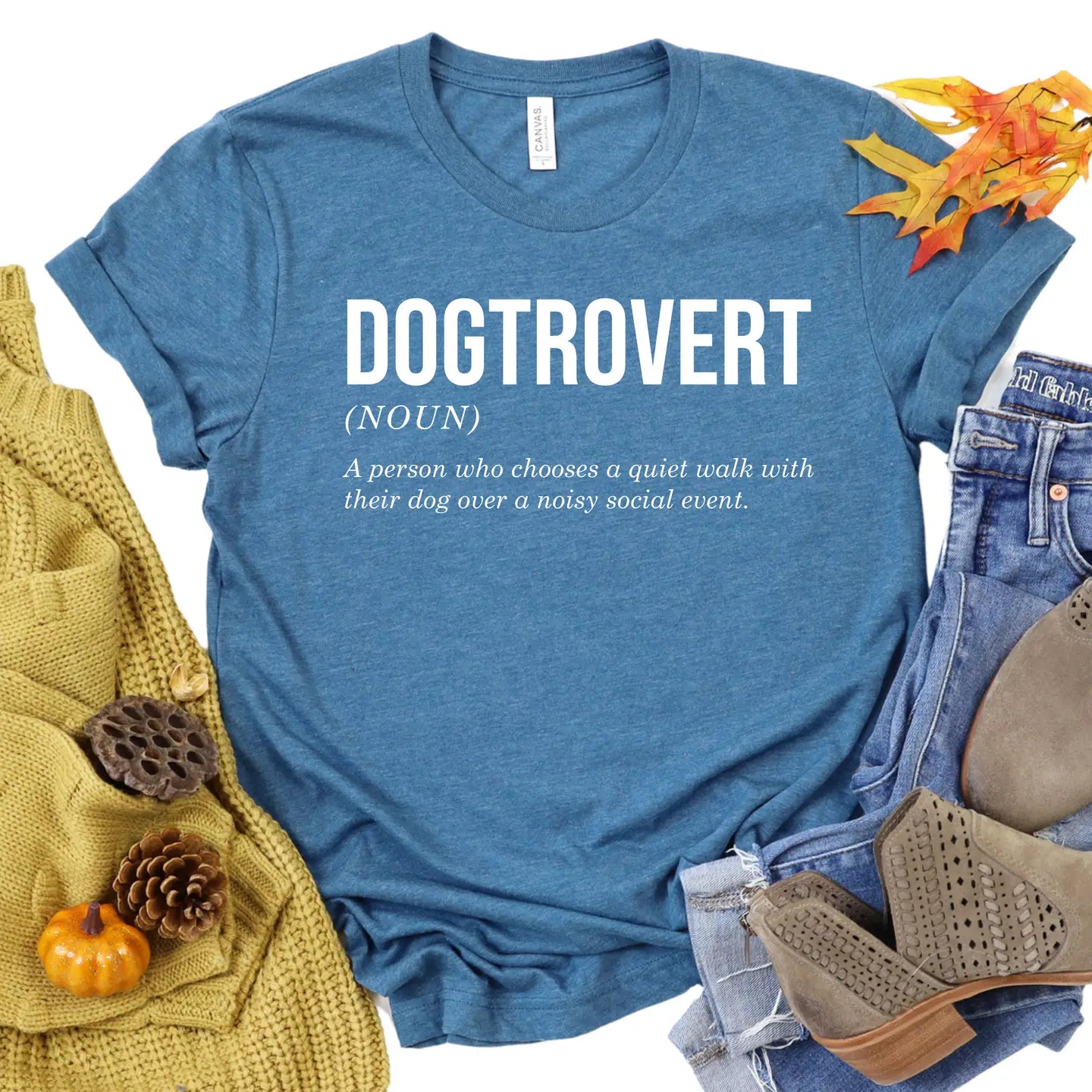 Blue t-shirt with 'DOGTRROVERT' definition text, surrounded by autumn-themed items.