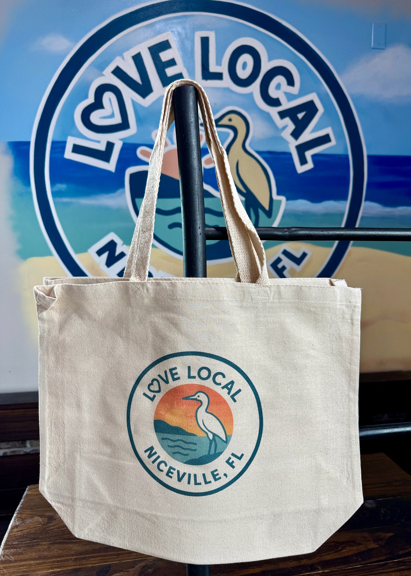 Beige tote bag with 'Love Local Niceville, FL' logo in front of a blurred background with a similar logo.
