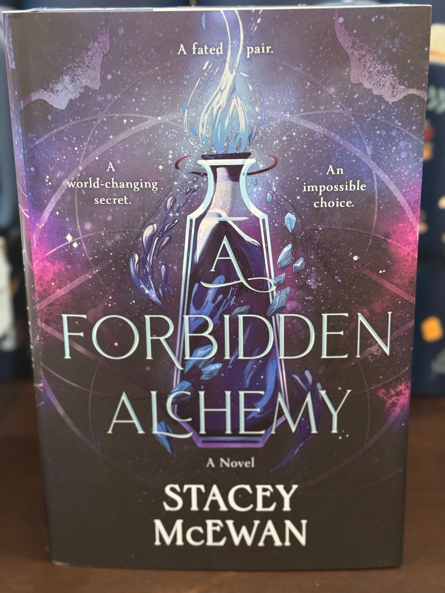 Book cover of 'A Forbidden Alchemy' by Stacey McEwan with a mystical design.