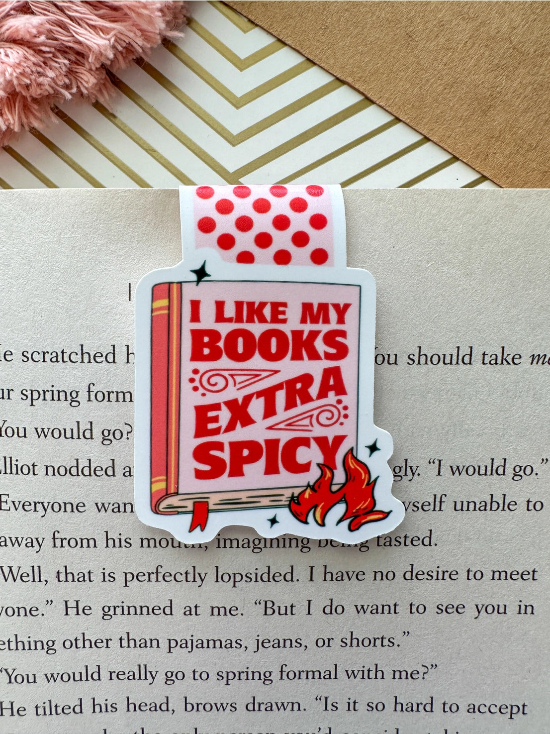 Bookmark with text 'I like my books extra spicy' on a book page.