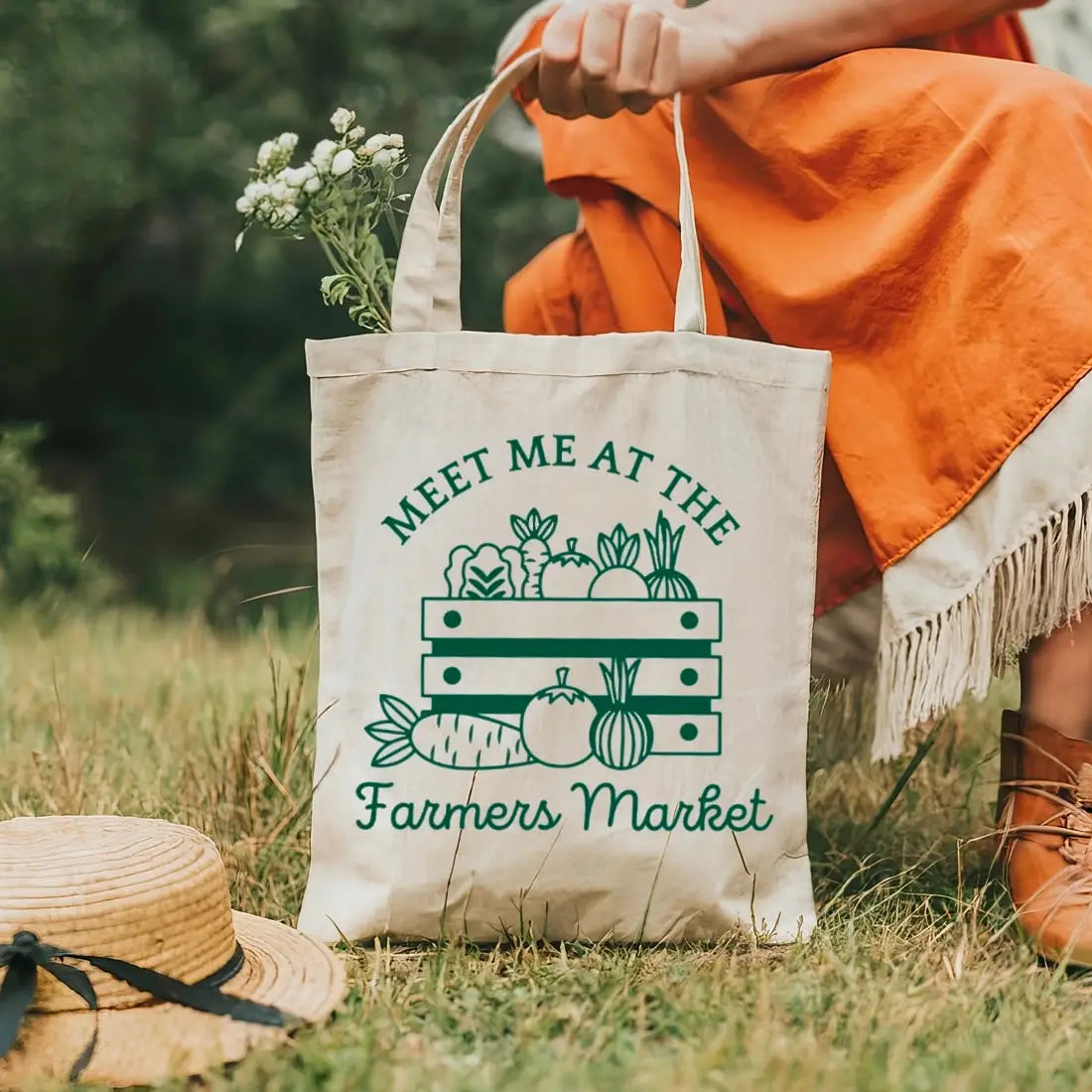 Tote bag with 'Meet Me at the Farmers Market' text and graphics on grass