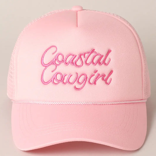 Pink cap with 'Coastal Cowgirl' embroidery on a beige background