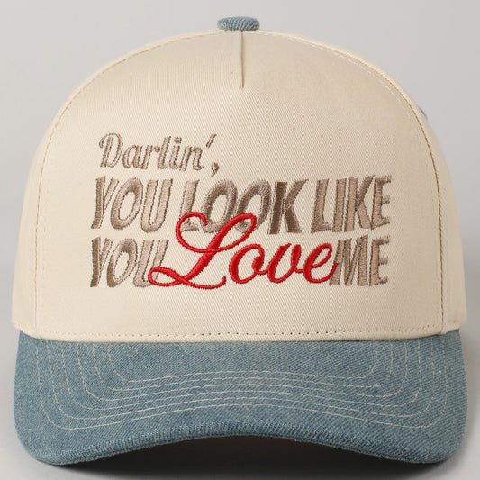 Cap with embroidered text 'Darlin', YOU LOOK LIKE YOU LOVE ME' on a gray background