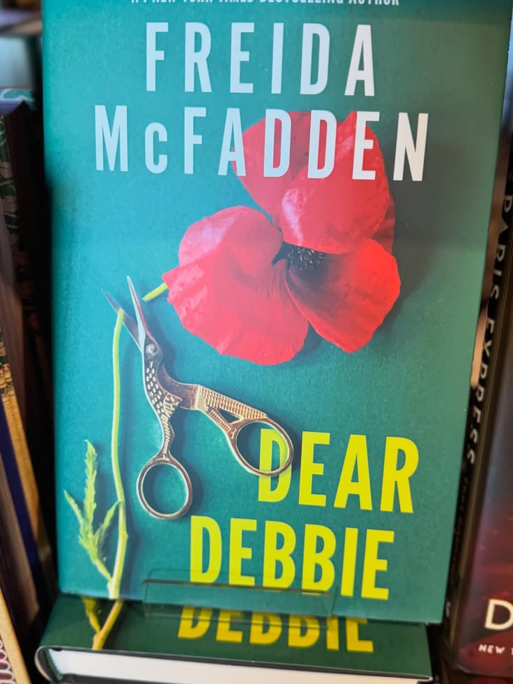Book cover of 'Dear Debbie' by Freida McFadden with a red flower and scissors on a teal background.