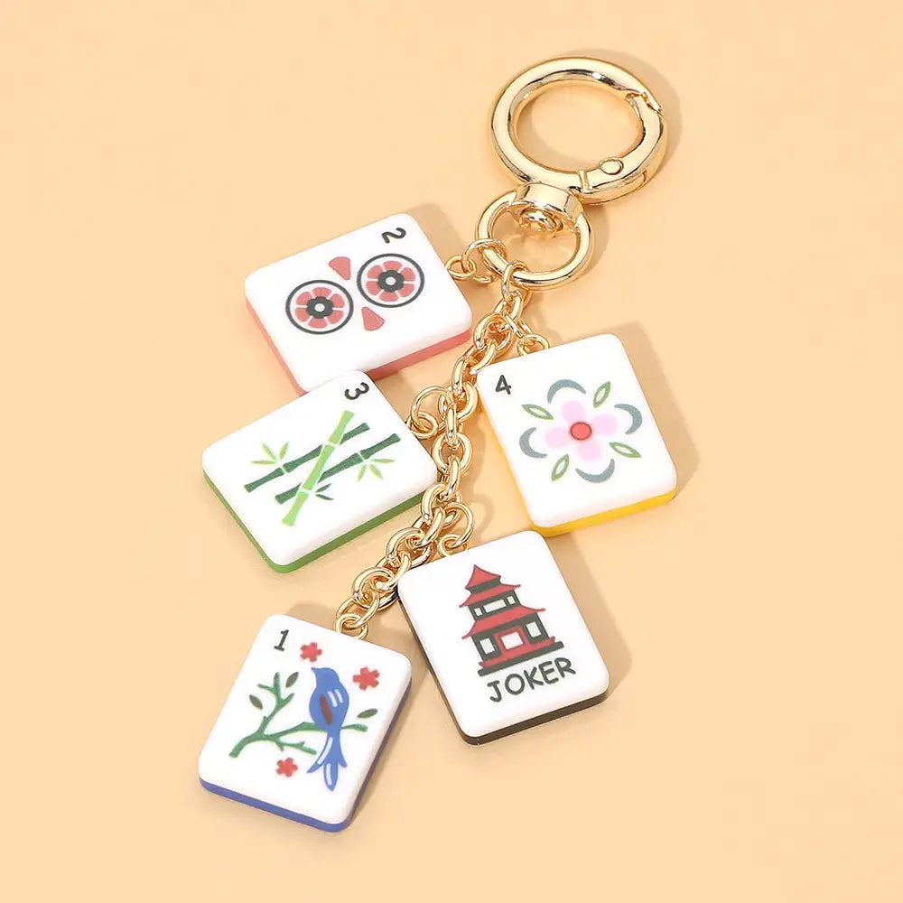 Keychain with Mahjong tile charms on a beige background