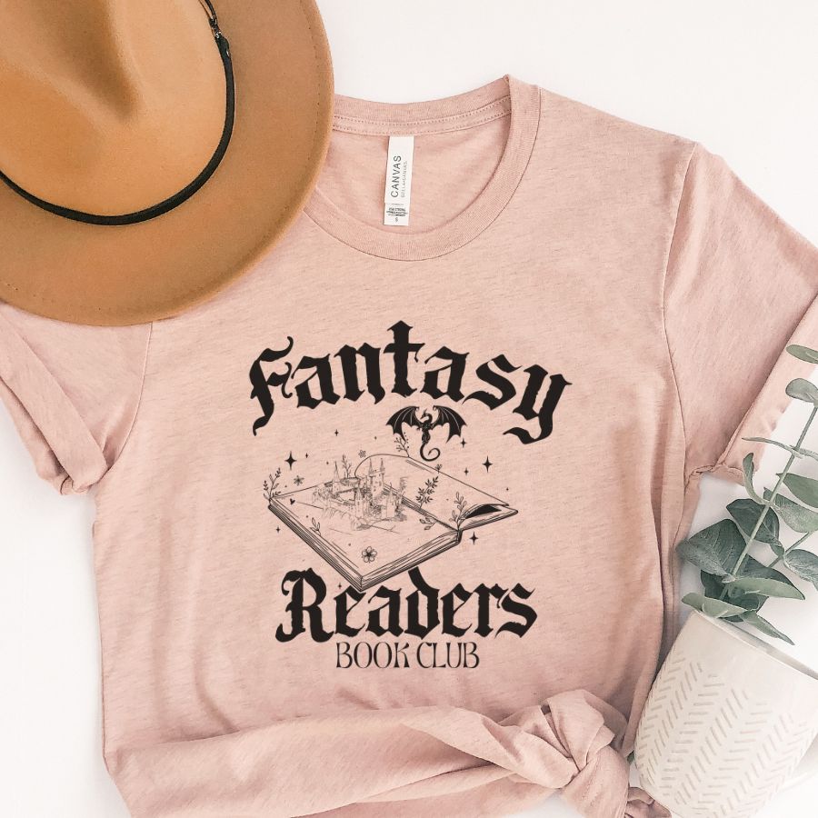 Pink t-shirt with 'Fantasy Readers Book Club' design, beige hat, and plant on a white background