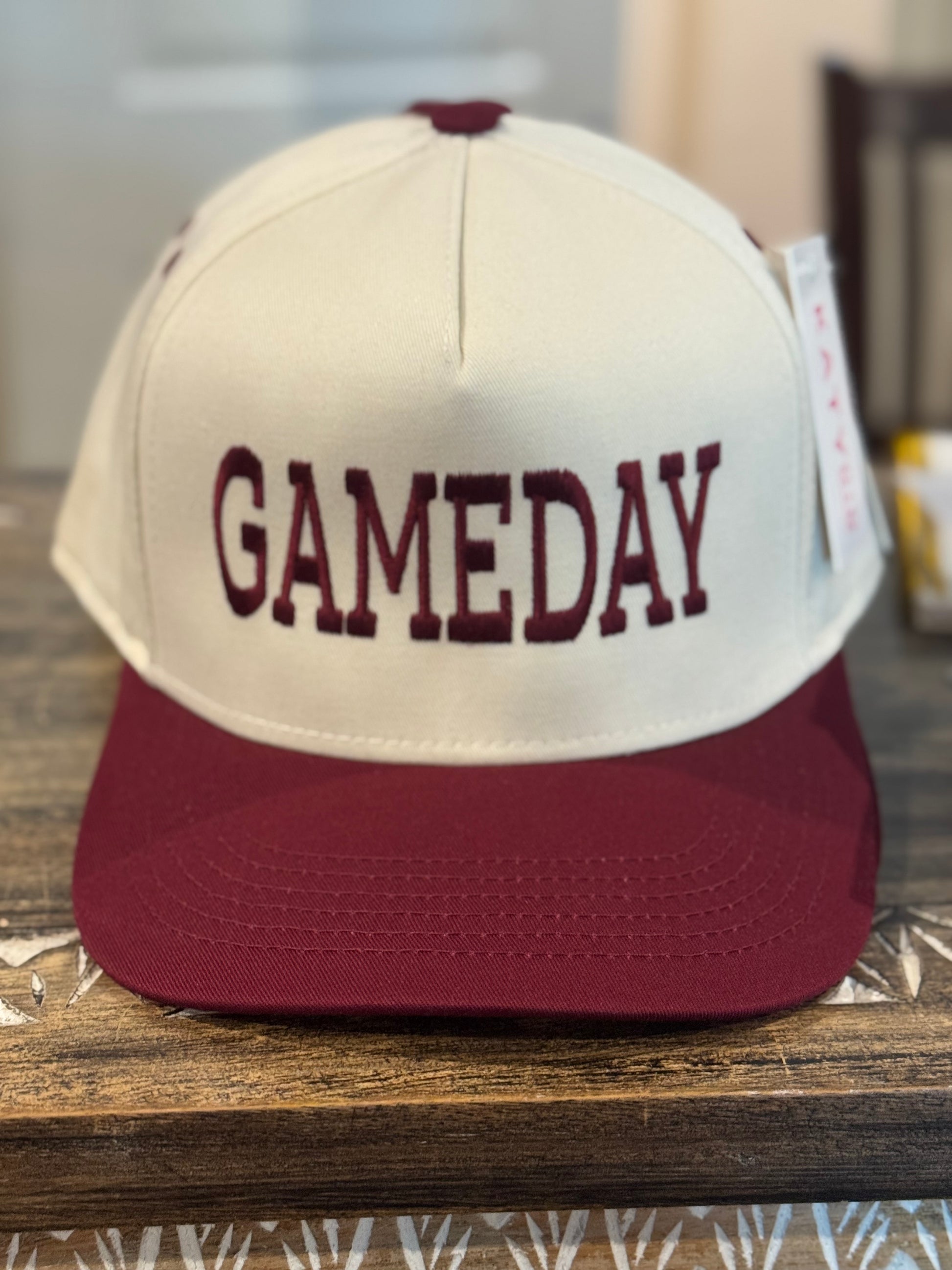 Trucker hat with 'GAMEDAY' text on a wooden surface