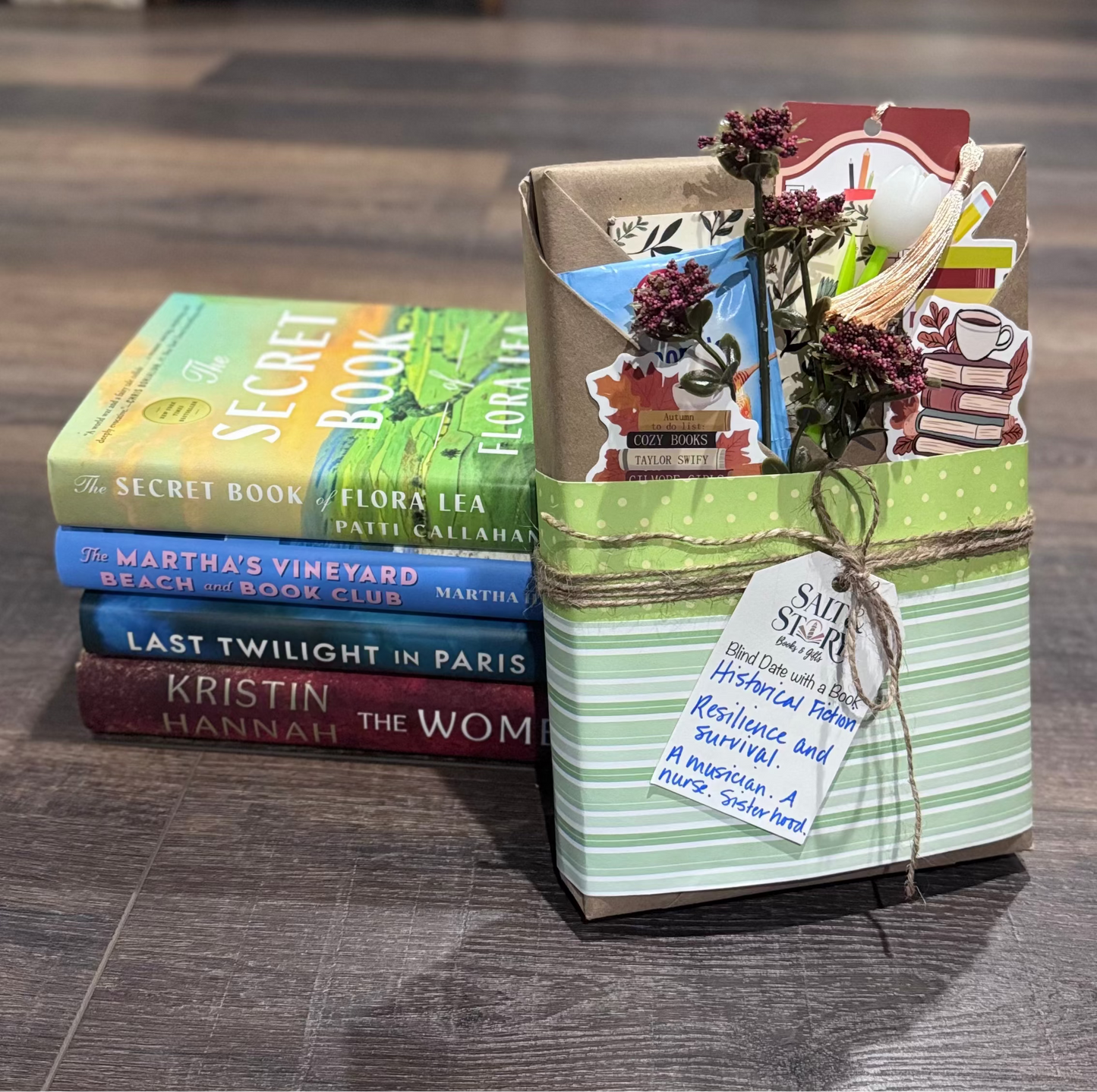 Stack of books with decorative packaging on a wooden floor