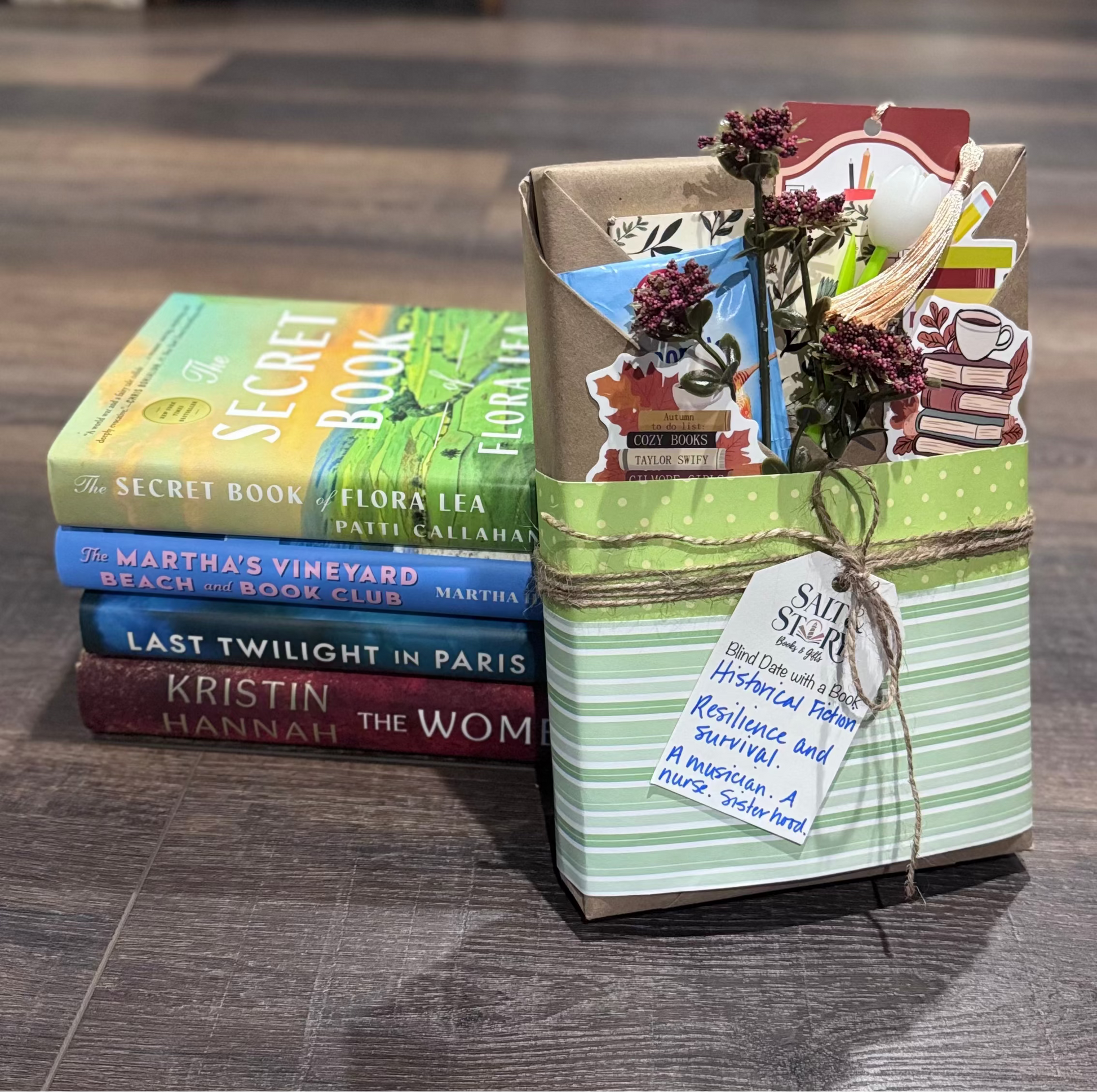 Stack of books with decorative packaging on a wooden floor
