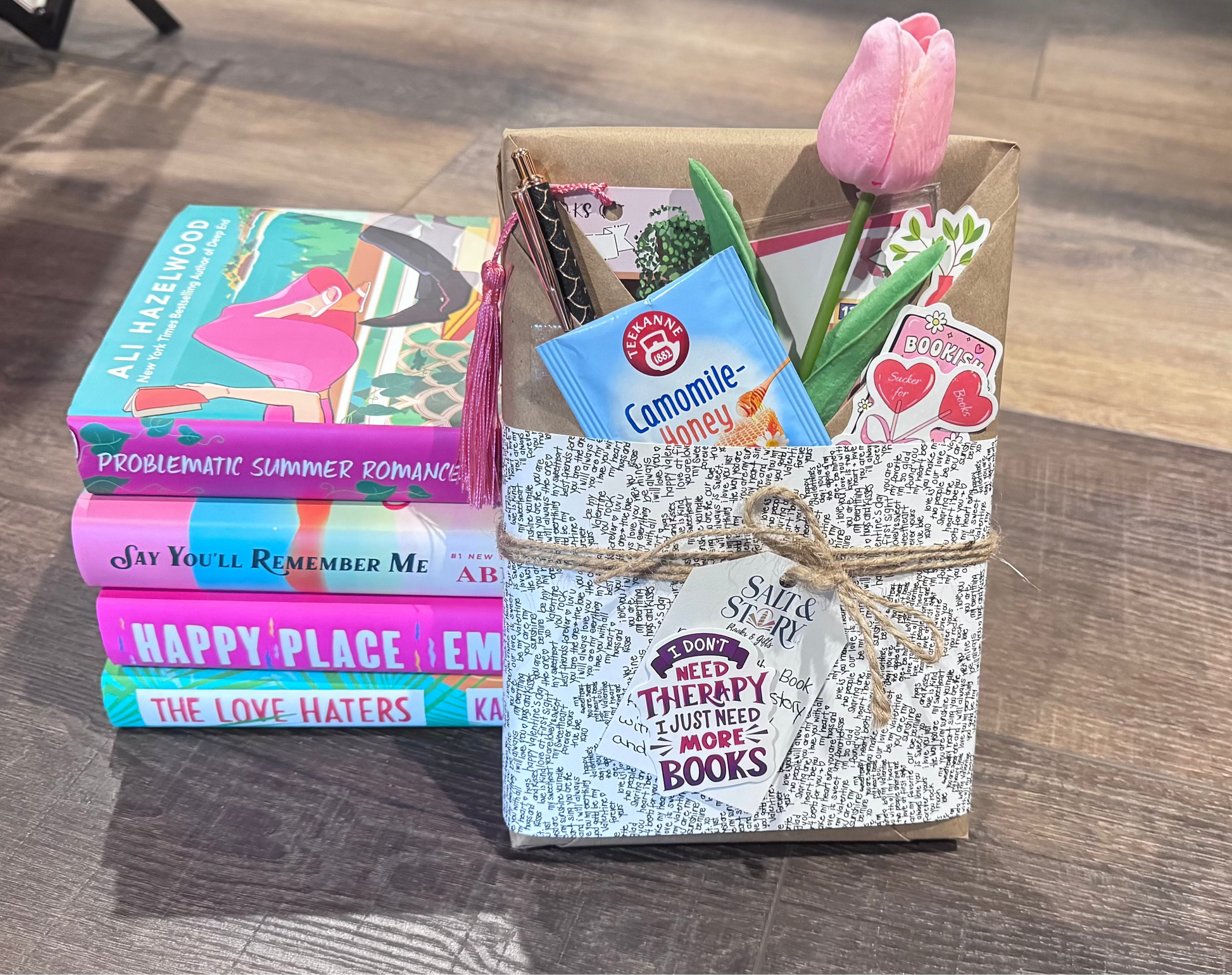 Stack of books with a decorative box on a wooden floor