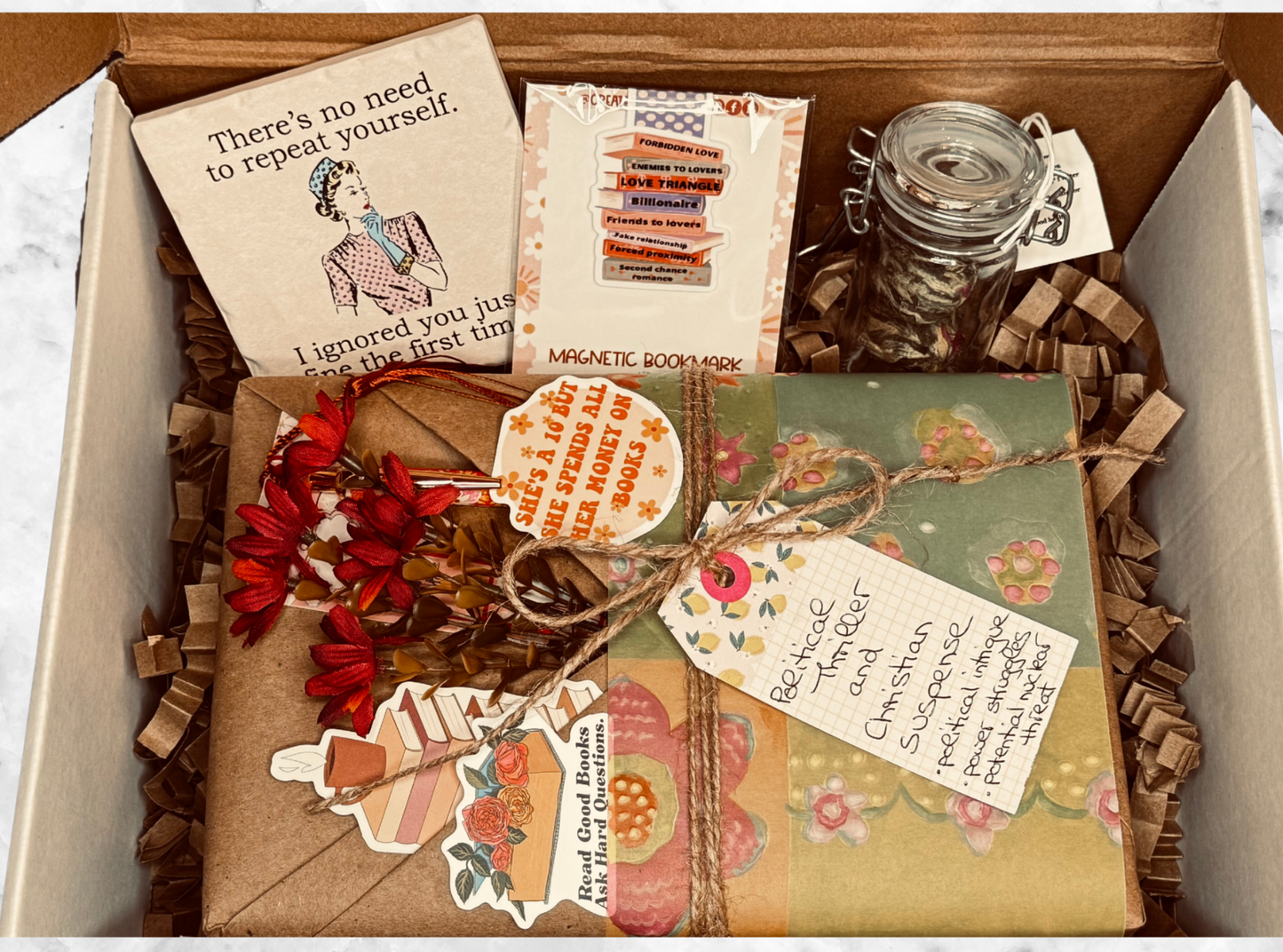 Box containing various items including a book, magnets, and decorative elements.