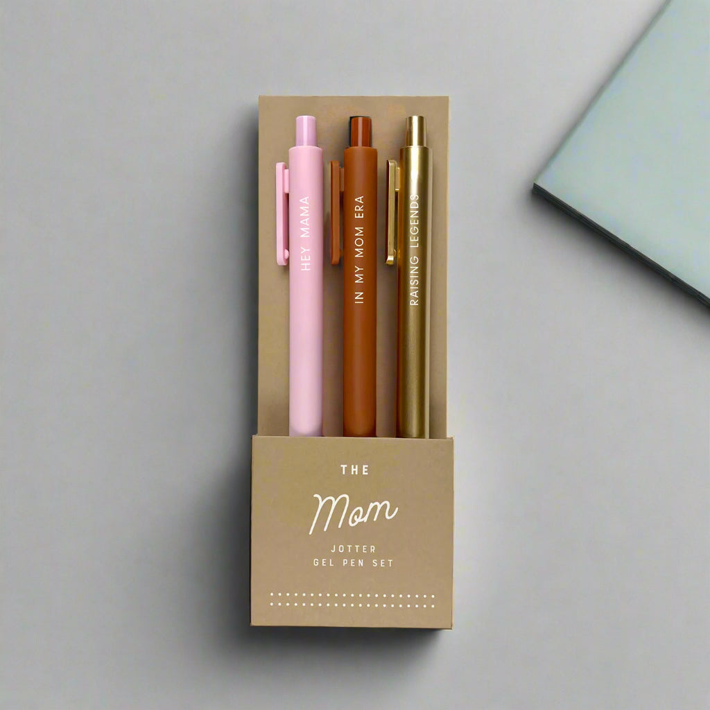 Set of three pens in pink, brown, and gold in a cardboard holder with 'The Mom Jotter Gel Pen Set' text.