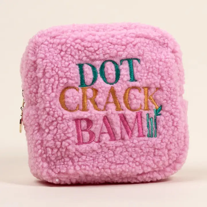 Pink textured pouch with colorful text on a beige background