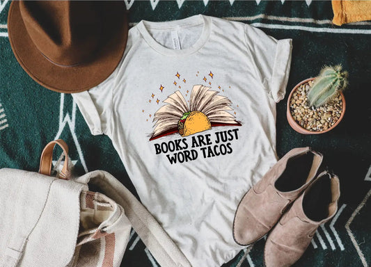 White t-shirt with a graphic design and text on a surface with a hat, bag, and shoes.
