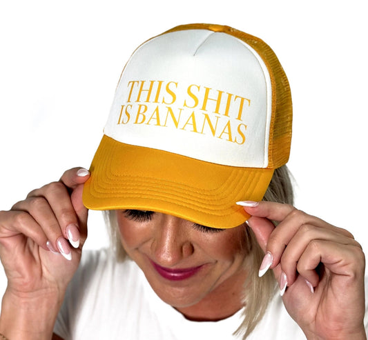 Person wearing a yellow and white cap with 'THIS SHIT IS BANANAS' text on a white background