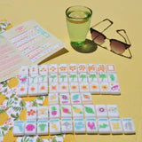 Set of colorful building blocks with a glass of water and sunglasses on a yellow surface
